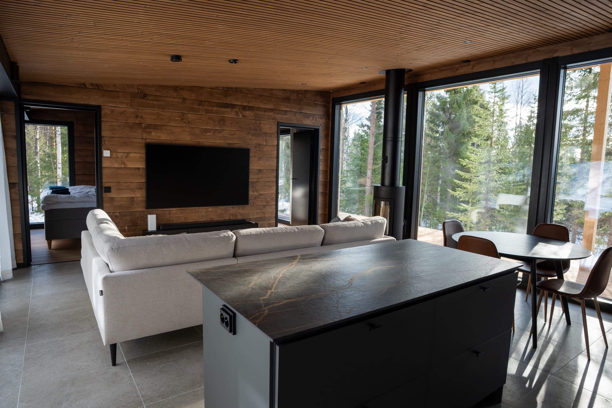 Villa Rekin olohuone, sohva ja ikkunanäkymä metsään